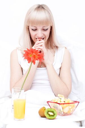 Cute girl has a breakfast in the bedの写真素材