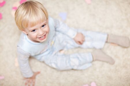 Sweet little kid sitting on floorの写真素材