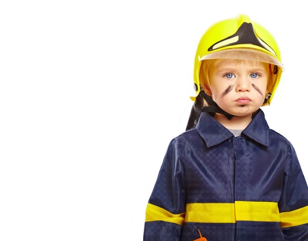 Serious little boy in fireman costume isolated on whiteの写真素材