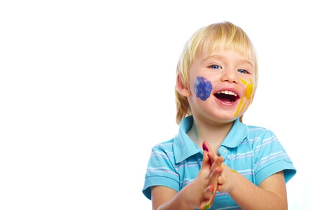 Happy kid with paints on face isolated on whiteの写真素材
