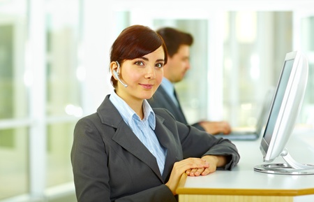 Telephone operators at the monitors smiling at the officeの写真素材