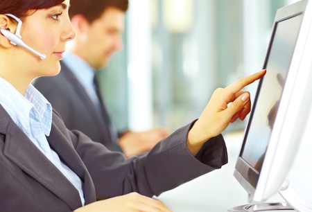 Image focused on hand of the customer support working in the office touching the screenの写真素材