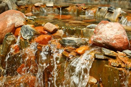 Colorful orange and gray rocks of the artificial indoor waterfall, interior decorationの写真素材