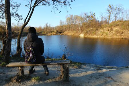 Back portrait of a woman admiring the beauty of a spring lakeの写真素材