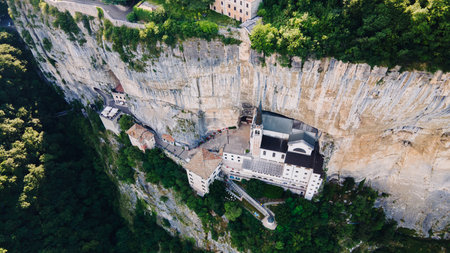 Aerial panoramic view of sanctuary church built into tall cliff in Italyの写真素材