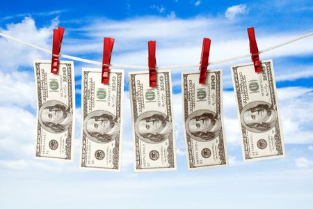 Dollars on a rope isolated on blue sky background.の写真素材