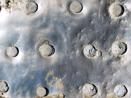 Riveted metal surface closeup background.