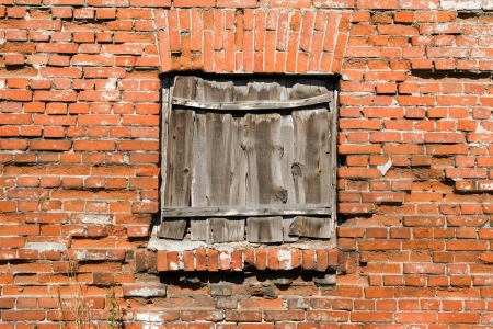 Blocked window on the red brick wall background の写真素材