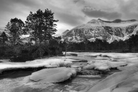 Winter river landscape with running waterの写真素材