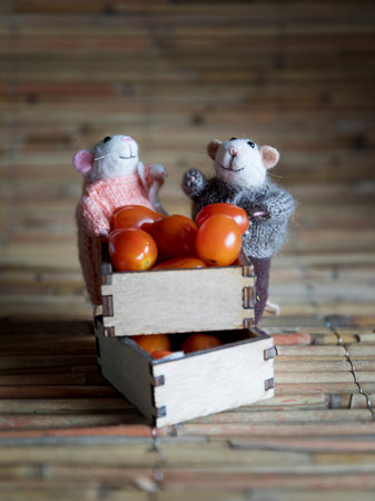 Tomatoes in a wooden box with a toy mouse on a wooden backgroundの写真素材
