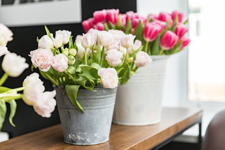 White and pink tulips in decorative buckets on the table. Nobody. Copy spaceの写真素材