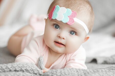 Cute litttle baby at home in the bedroom. An infant indoors. 6th month child portrait. Adorable cute...