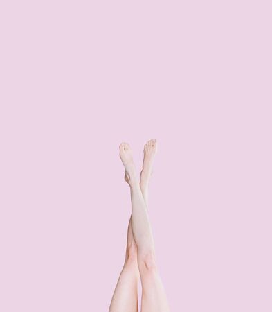 girl legs on a  pink background raised upの写真素材