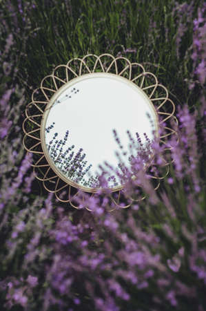 round mirror lies in lavender flowers top view backgroundの写真素材