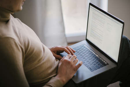 close up hands multitasking man using laptop connecting working from home