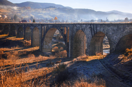 large stone bridge near the lake among the misty Carpathian mountains, general plan side viewの写真素材