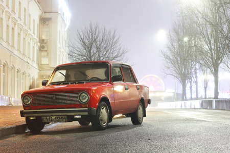 Chernihiv, Ukraine - January 10, 2020: Red vintage car VAZ 21011 in a foggy city.のeditorial素材