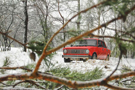 Chernihiv, Ukraine - January 20, 2020: Old red VAZ 21011 car in the winter forest. Abstract photoのeditorial素材