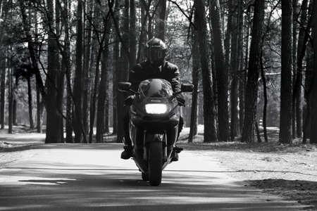 Chernihiv, Ukraine - April 7, 2020: A motorcyclist on a Kawasaki motorcycle on a forest background. Motorcycle in motionのeditorial素材