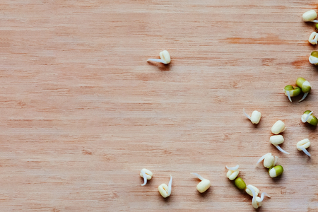 Mung beans sprouts scattered on a wooden table, top view, copy spaceの写真素材