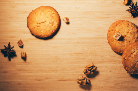 Top view of round crunchy sweet biscuits with candied fruit and nuts, on textured wooden backgrounの写真素材