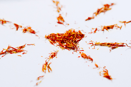 Selective focus close up Red Saffron in shape of mandala with heart on white background. Delicate flower threads. Natural healthy spice. For cafe menu or catalogの写真素材