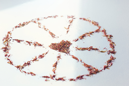 Selective focus close up Red Saffron in shape of circle with heart on white background. Delicate flower threads. Natural healthy spice. For cafe menu or catalogの写真素材