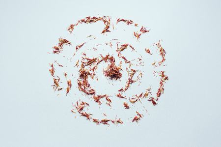 Red Saffron in shape of circle on white background. Delicate herb threads, plucked from flowers and dried. Top view of natural healthy spice. Copy space for text and designの写真素材