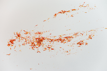 Red Saffron on white background. Delicate herb threads, plucked from flowers and dried. Top view of natural healthy spice. Copy space for text and designの写真素材