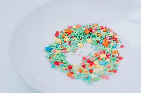 Selective focus Festive abstract multicolored candy sprinkles. Yellow red green orange blue circles,...