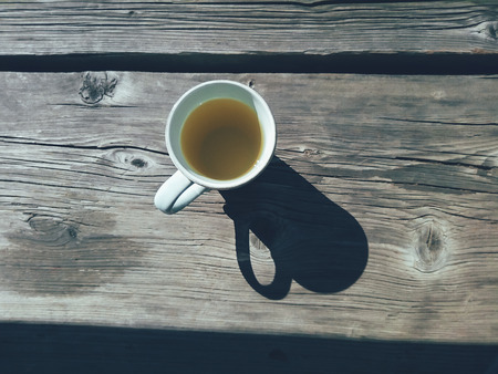 cup of tea on wooden terrace background. Top view. Daylight, hard shadows. Still life in rustic style. Countryside lifestyle, vacation, breakfast concept. Copy spaceの写真素材