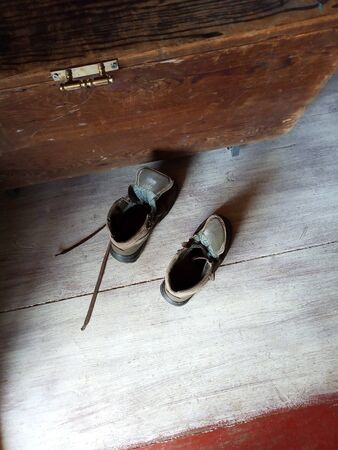 Pair of old brown shoes on wooden floor, shoe retro box next to them. Top view. Natural lightの写真素材