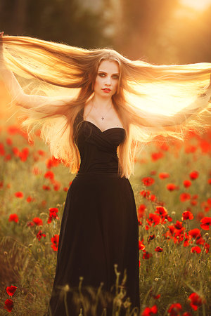 Beautiful woman in a poppy field with flowers.の写真素材
