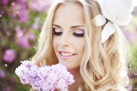 portrait of young beautiful woman girl on background of bougainvillea purple violet flowers in blossomの写真素材