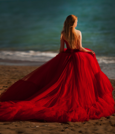 A woman in a red dress on the beach. Maritime vacation. Journey to the seaの写真素材