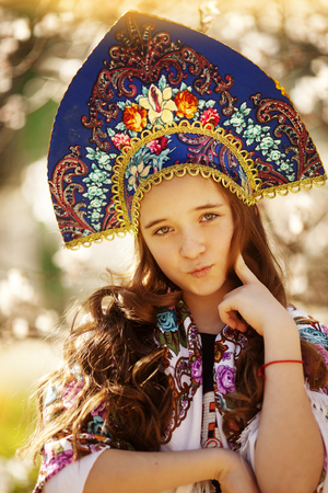 Little happy girl playing under blooming cherry tree with pink flowers.の写真素材