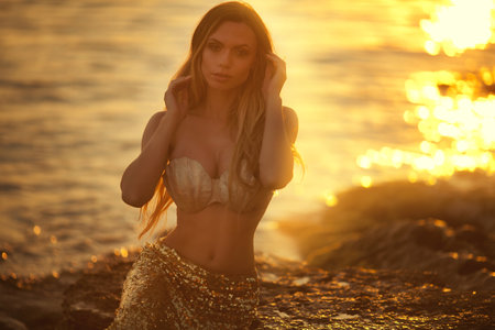 Beautiful fashionable mermaid sitting on a rock by the seaの写真素材