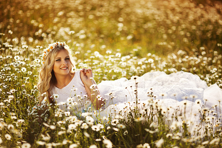 beautiful blonde in a chamomile fieldの写真素材