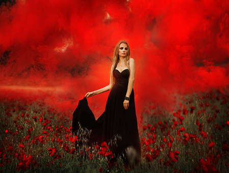 girl with a bouquet of poppies in black dressの写真素材