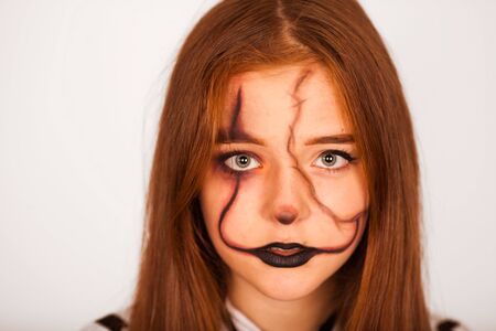 Mystical girl with a painted skull on her face in the style of Halloween. close up portrait of...