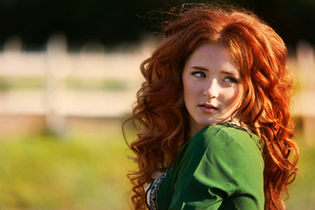 mysterious red-haired warrior girl stands. Lady elven princess holds bow and arrow.