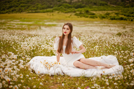 Beautiful girl is relaxing lying on the grass in the gardenの写真素材
