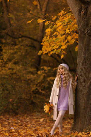 autumn leaves falling on happy young woman in forest. autumn landscapeの写真素材