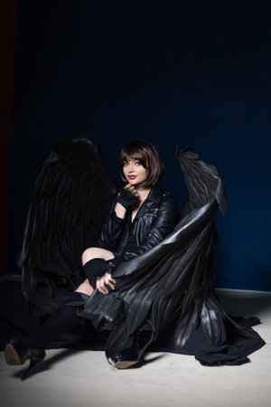 Black angel on the stairs. A young girl with black angel wings in a black long dress.の写真素材