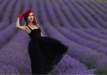 Beautiful girl is wearing fashion dress at field of lavender. girl walking through a lavender fieldの写真素材