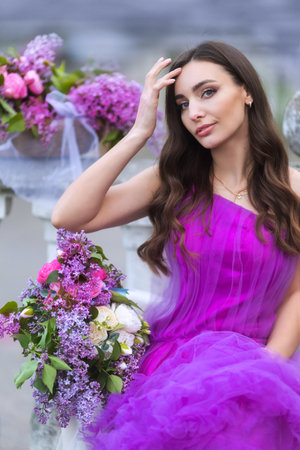 Fashion Model in Lilac Flowers, Young Woman in Beautiful Long Dress Waving on Wind, Outdoor Beauty Portrait in Blooming Gardenの写真素材