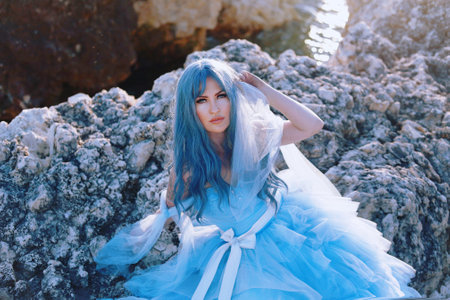 magical photo of a girl with blue hair in a blue dress against the backdrop of the sea. sea mermaidの写真素材