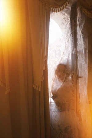 Girl in long vintage dress on antique sofa. luxury bedroom in gold