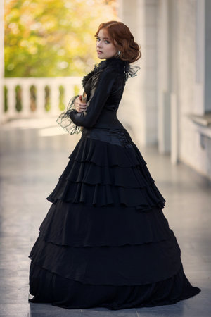 young girl in black vintage dress in park among columns. romantic photoの写真素材