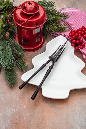 Christmas table setting concept in dark tones with red berries and fir treeの写真素材